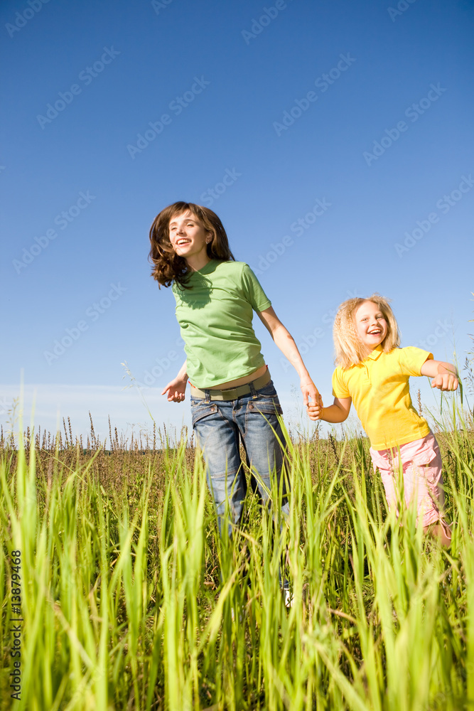 Happy woman and girl making exercises on field Happy woman and girl making exercises on field