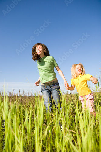 Happy woman and girl making exercises on field