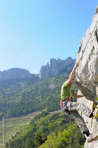 Jeune homme escaladant une falaise dans le Luberon.