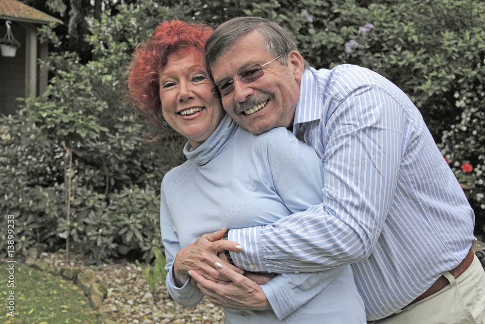 Obraz premium Elderly couple hugging in their garden