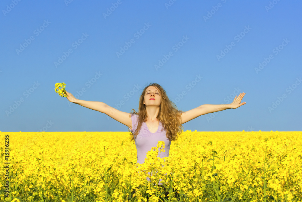 woman in rape(canola) field enjoying the open air woman in rape(canola) field enjoying the open air