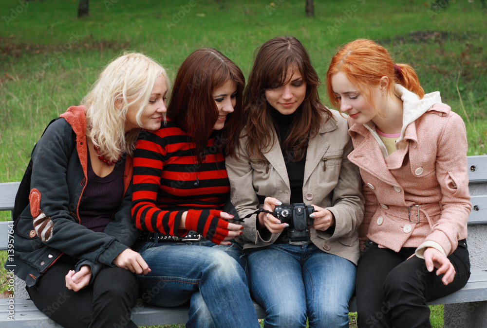 Four girls having fun with a digital camera
