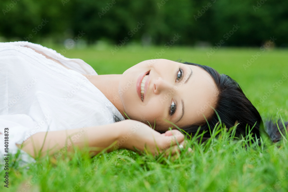 Sexy smiling woman laying on grass Sexy smiling woman laying on grass