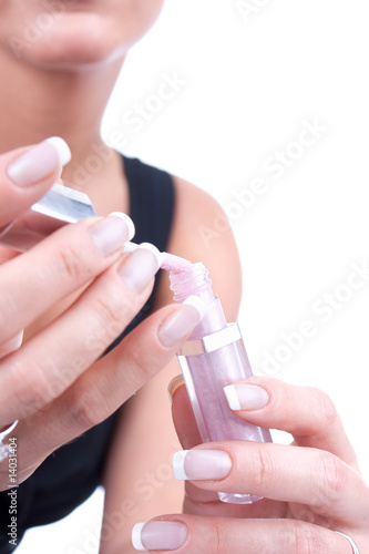 Beautician s hands applying lipgloss