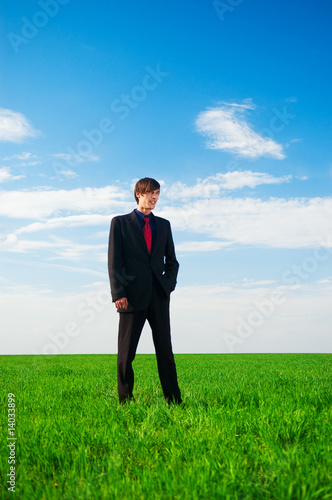 serious businessman standing at the grass