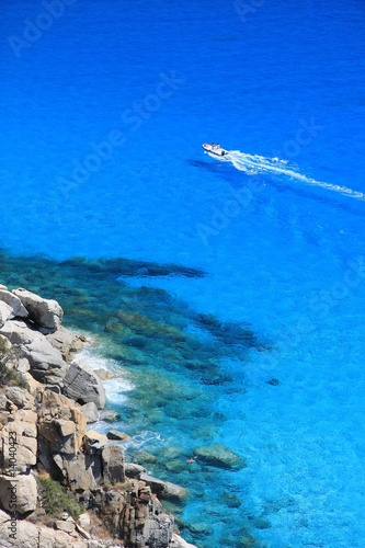 Gommone naviga tra le azzurre acque della Sardegna photo