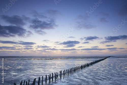 a colorful sunset at the beach with a blue sky