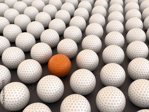 Orange golf ball among white balls