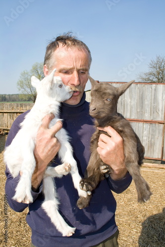 The portrait of farmer with two goatlings. photo