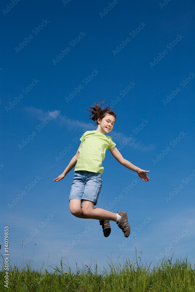 Girl jumping, running against blue sky