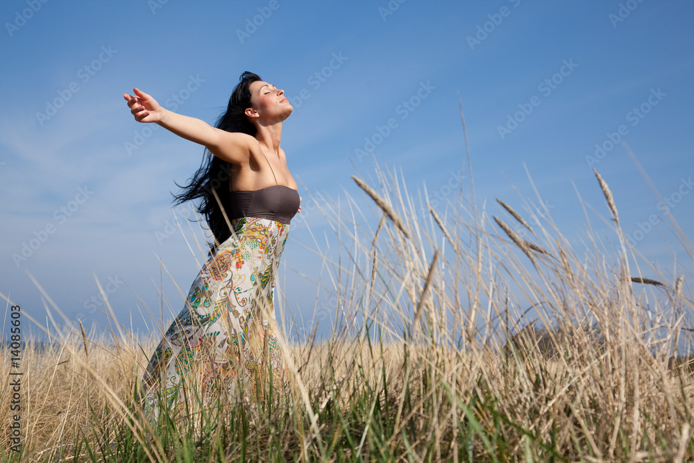frau geniet freiheit im feld vor blauem himmel