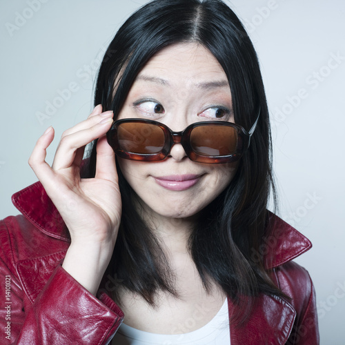 Tableau sur toile femme curieuse regardant par dessus ses lunettes de soleil