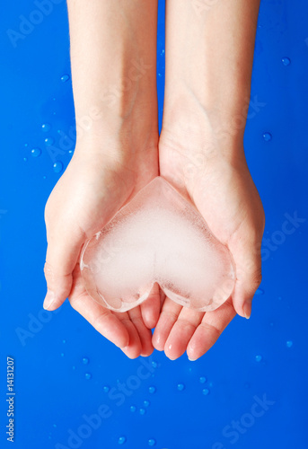 Ice heart in hands photo