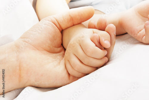 Hand of the child in a hand of mother