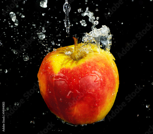 fresh water splash on red apple on black background