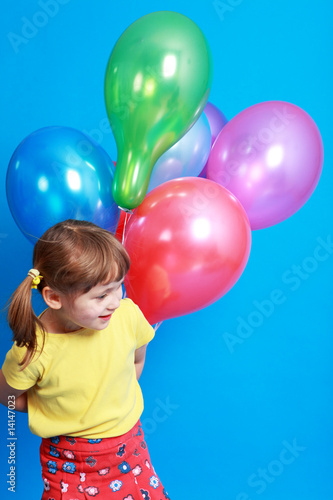 little girl holding colorful balloons on a blue background