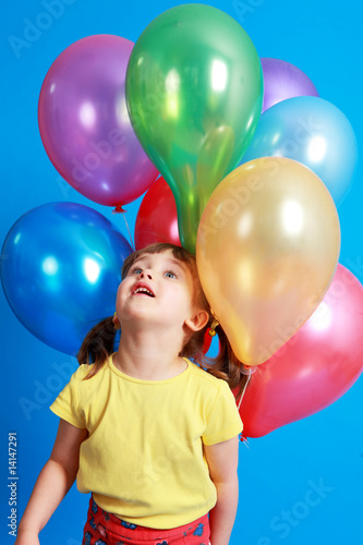 little girl holding colorful balloons on a blue background