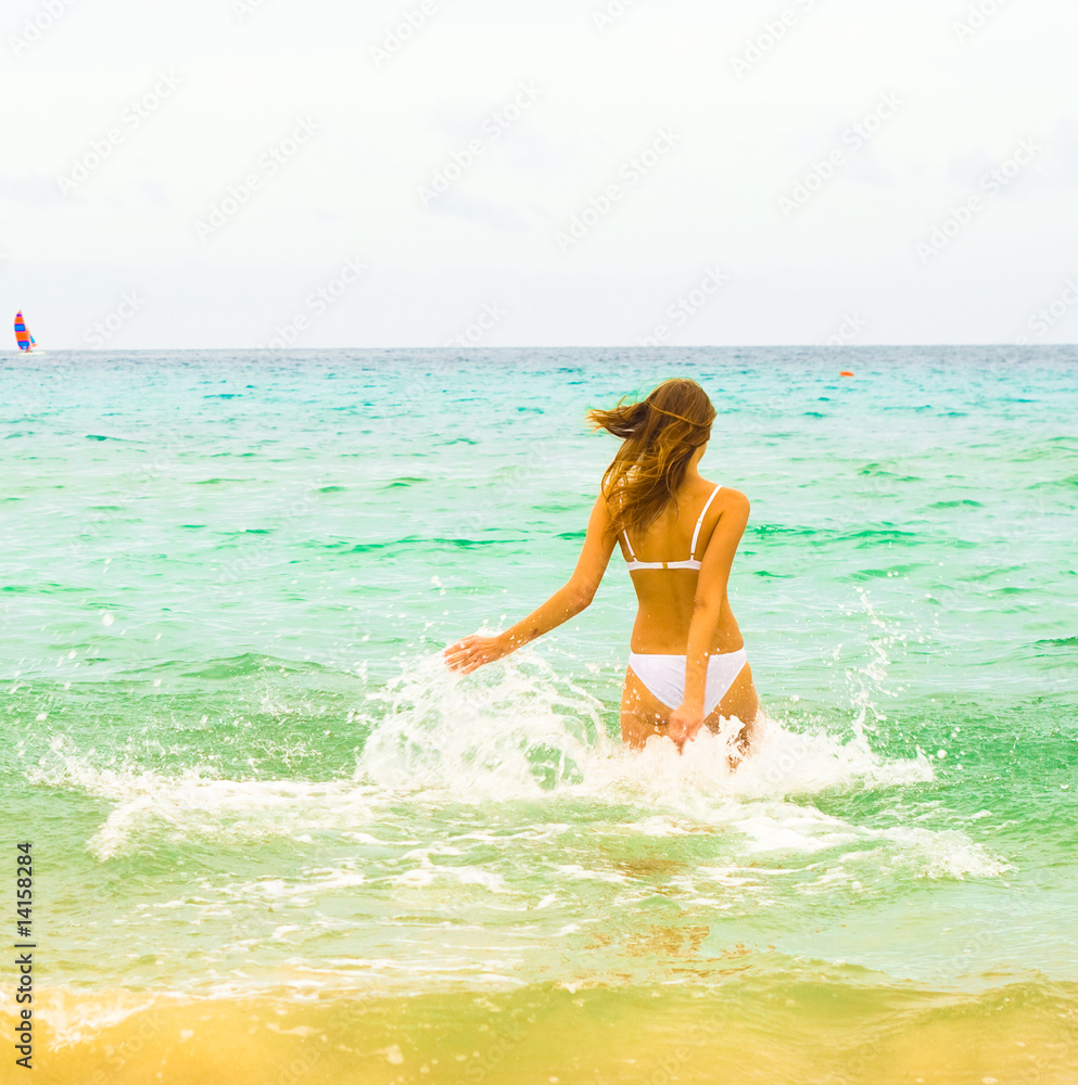 Girl in bikini running by a lovely sea