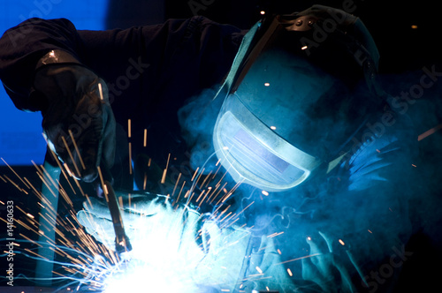 man at work: welder with spark arcing