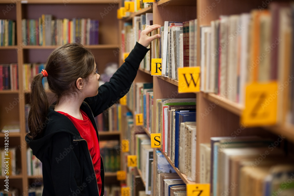 Young girl in library looking for books Young girl in library looking for books