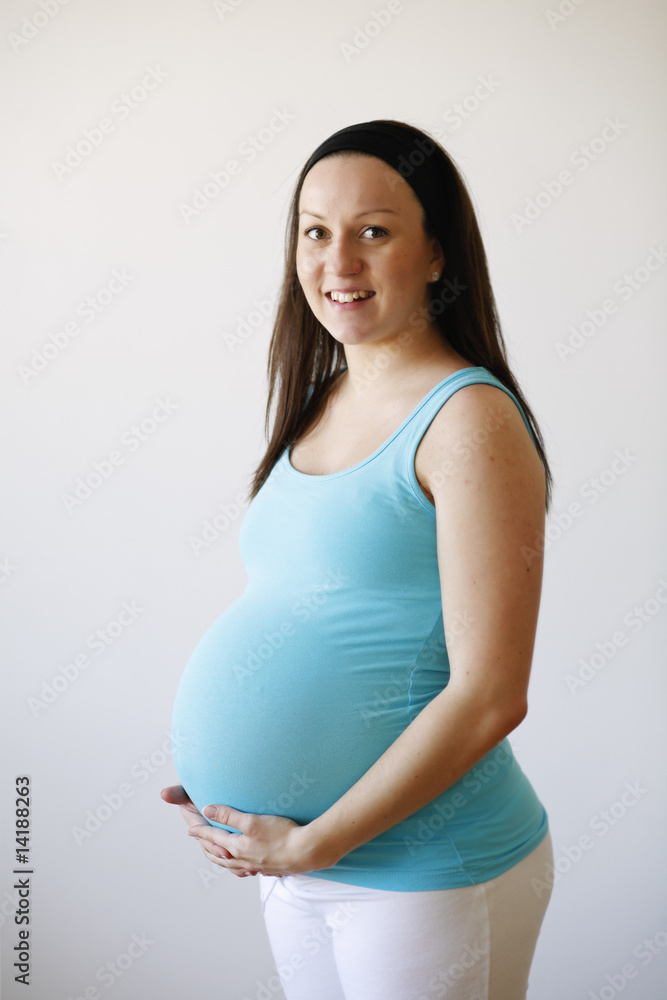 Young smiling pregnant woman holding her tummy. Young smiling pregnant woman holding her tummy.