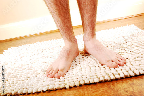 Man's legs on a bathmat