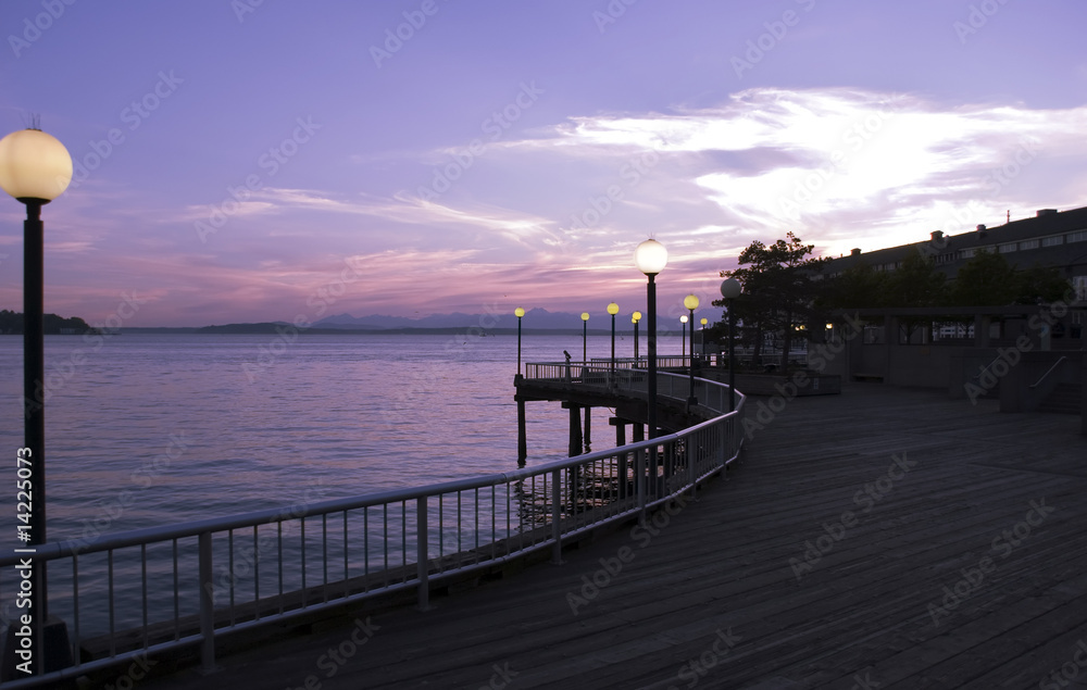 Obraz premium Wooden walkway along the pier at sunset