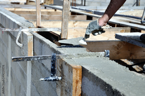 Maçon étalant le ciment sur le mur