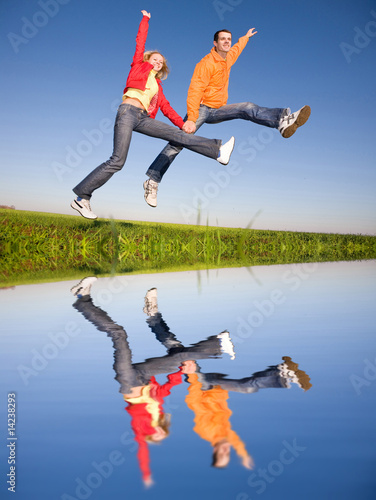 Happy smiling couple  jumping in blue sky