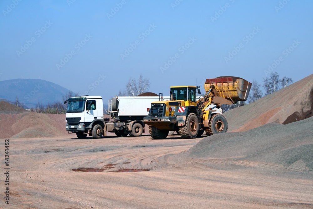 Heavy bulldozer loading ballast on the lorry