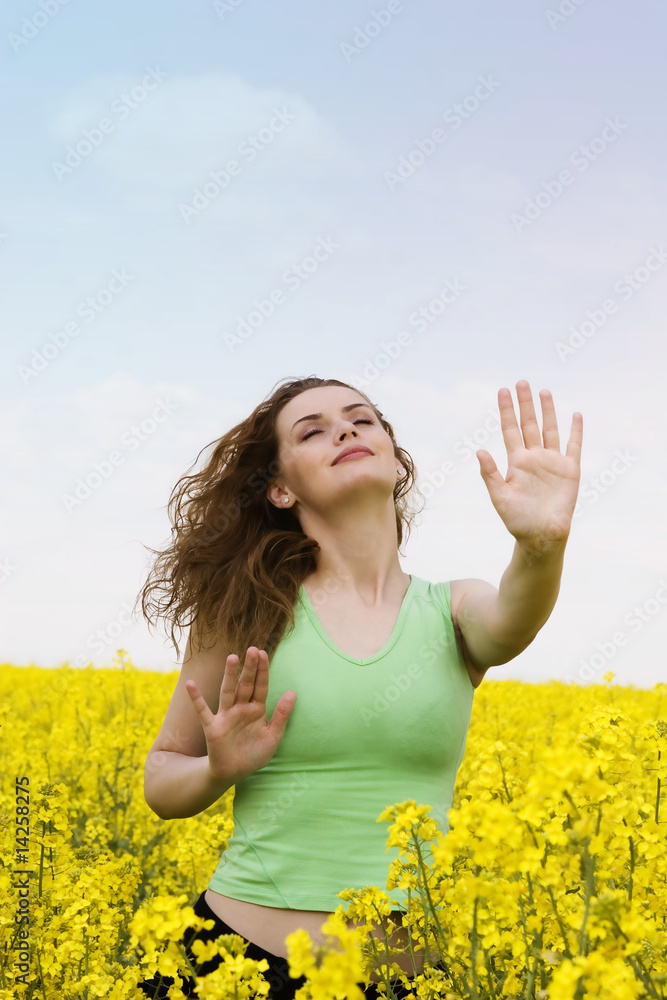 Naklejka premium Yoga woman in rape flower field