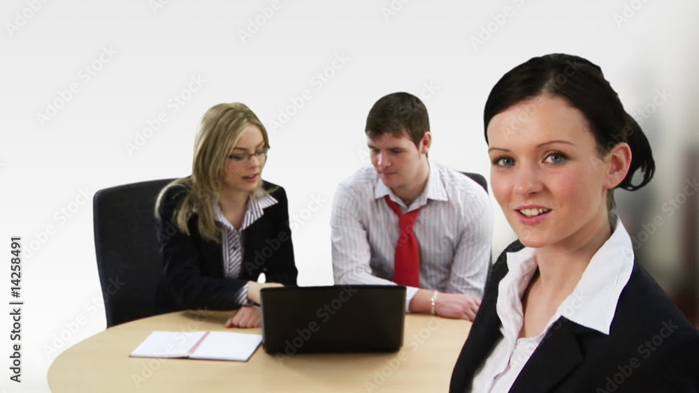 Young businesswoman with her team in the background Young businesswoman with her team in the background
