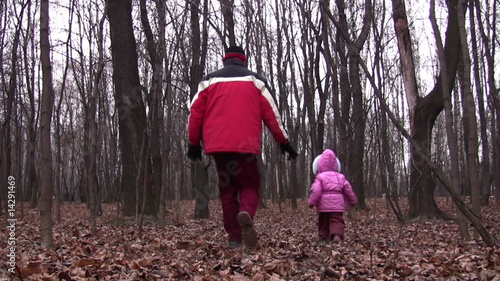 behind walking father and little girl in winter park photo