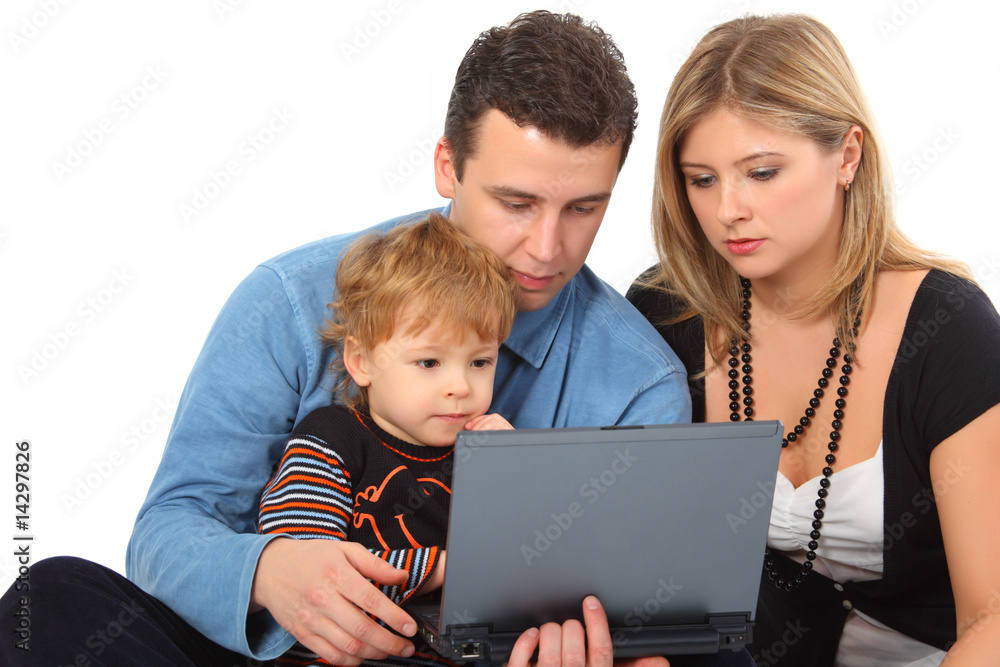 Parents whit son look on notebook