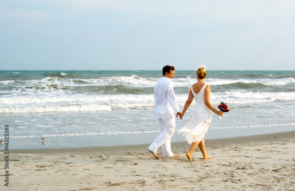 Newly weds walking along the ocean Newly weds walking along the ocean