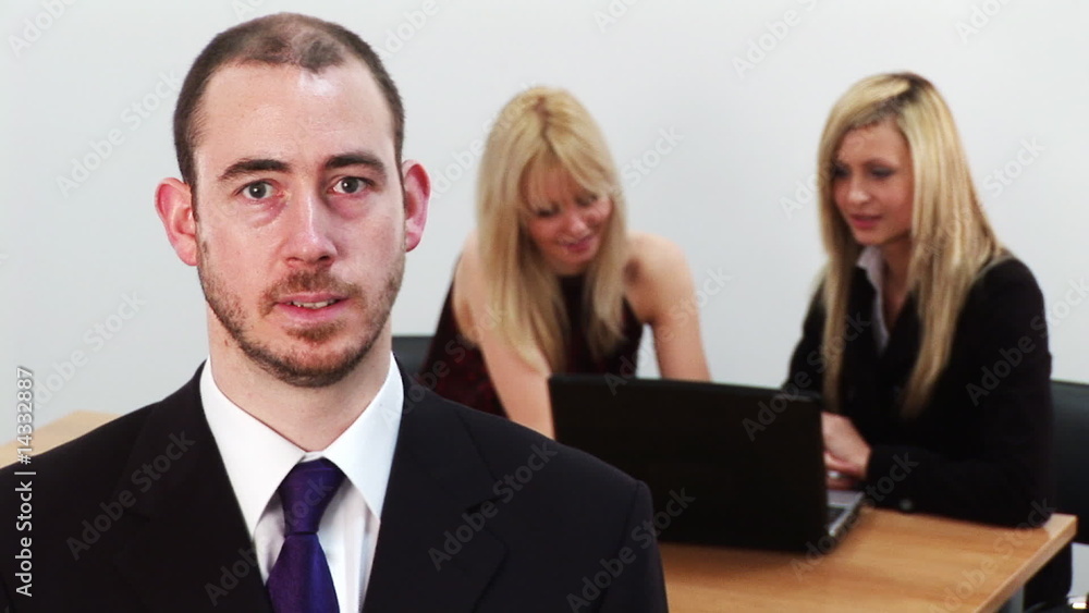 Serious businessman with his team in the background Serious businessman with his team in the background