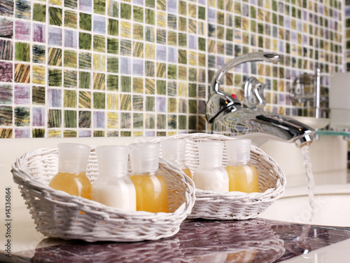 Baskets with bottles of shampoo the conditioner a shower gel in bathroom. Rest and hotel series photo