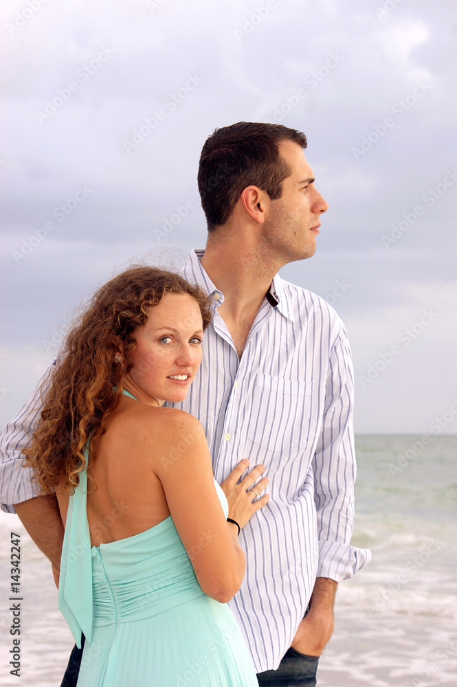 attractive couple at ocean he is looking at sea she is looking a attractive couple at ocean he is looking at sea she is looking a