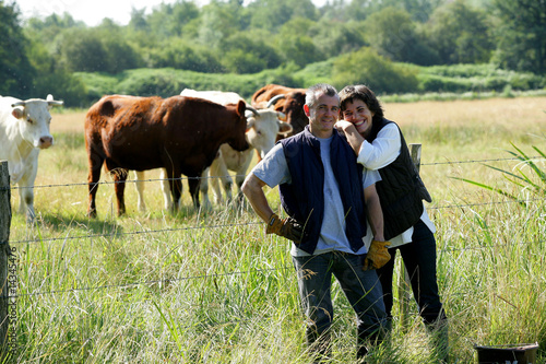 Photo couple d'éleveurs avec des vaches