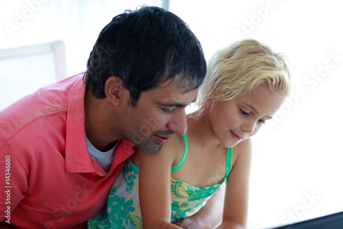 Father and daughter playing with a laptop