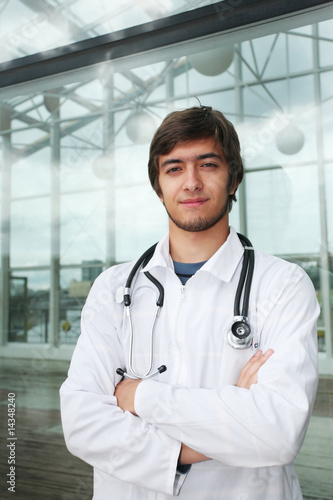 Portrait of a doctor in front of hospital glass wall photo