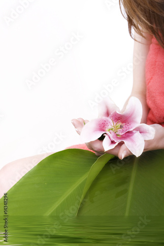 Flower in a hand and petals in water