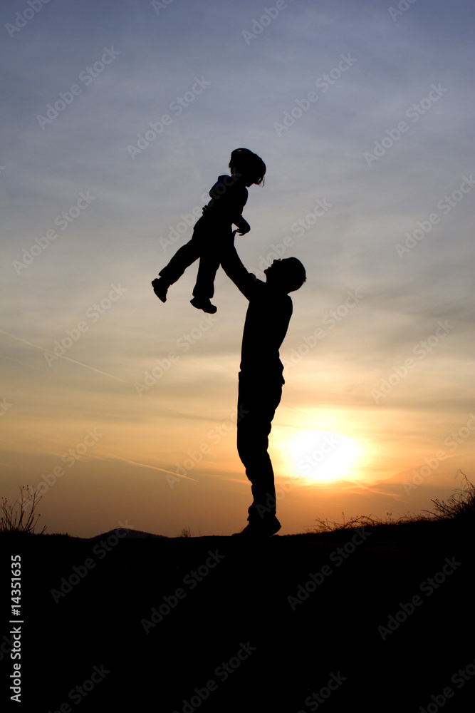 fun and love of father and child in sunset - silhouette