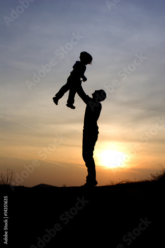 fun and love of father and child in sunset - silhouette