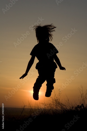 jump of little girl in sunset - silhouette