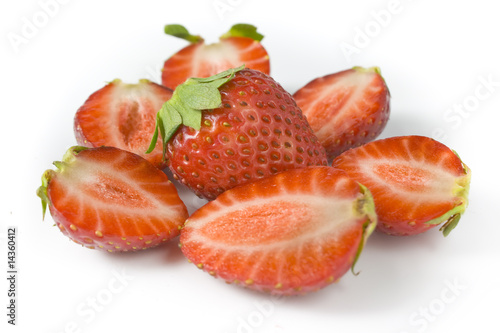 whole strawberry and the berries of a strawberry cut on halves.