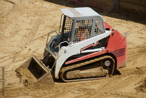 A small tracked skid loader at a construction site