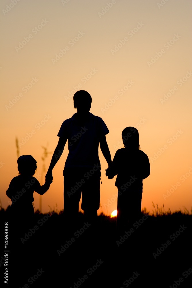 mother and children - silhouette by sunset