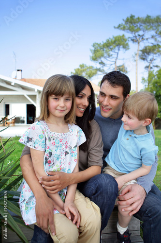 Family sitting in front of a house