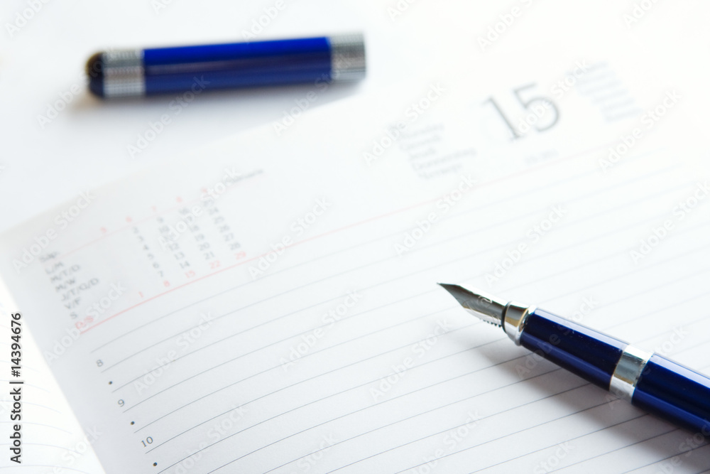 pen on a top of day planner pen on a top of day planner